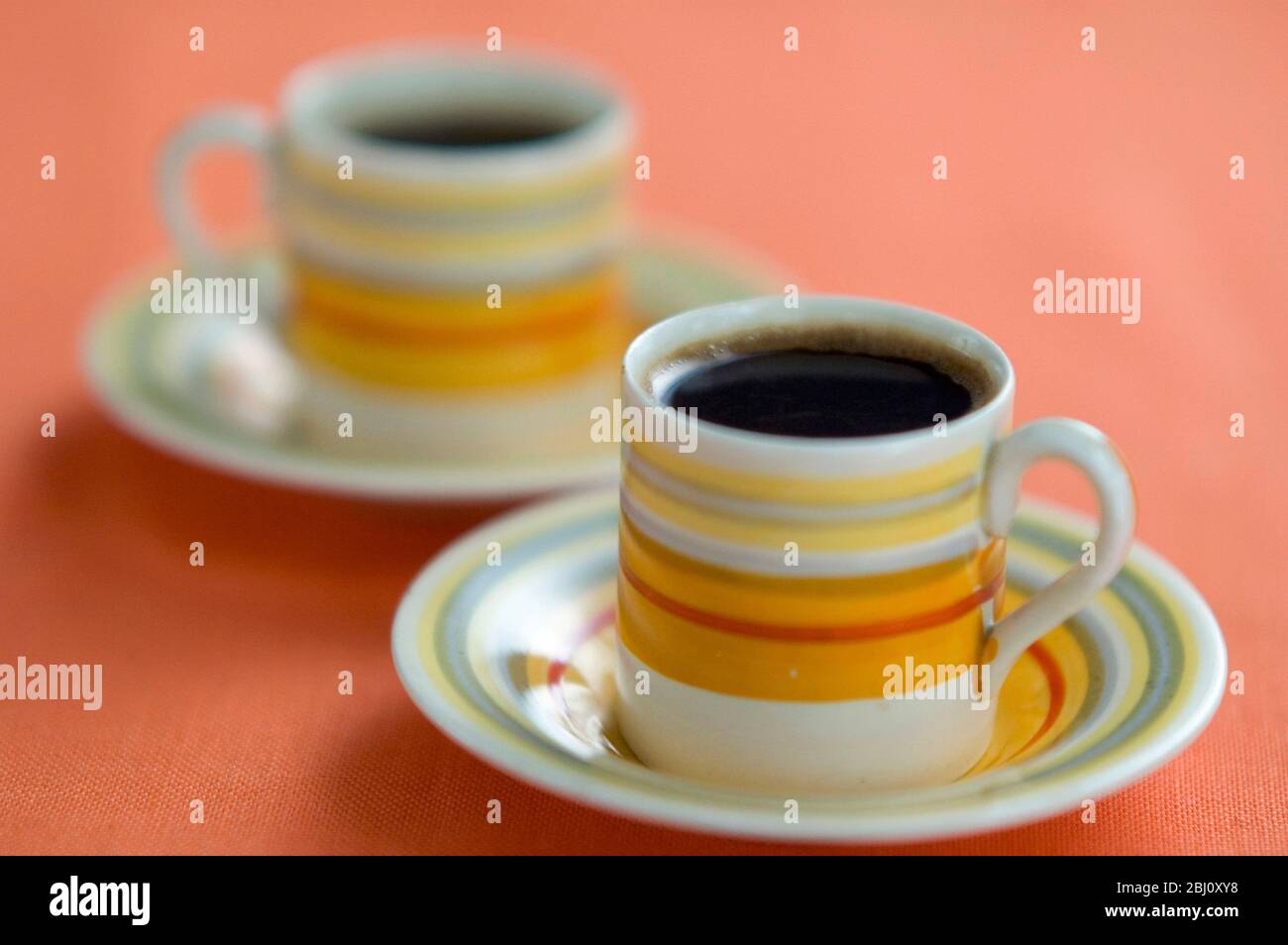 Zwei kleine Kaffeetassen mit schwarzem Kaffee nach dem Abendessen - Stockfoto