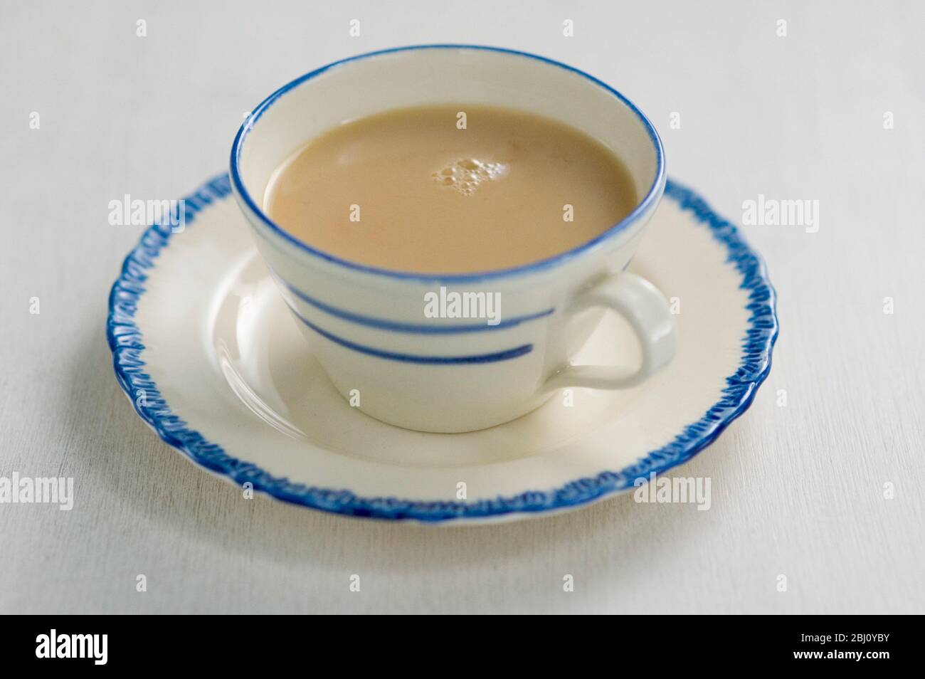 Blau und Creme porzellan Tasse und Untertasse mit milchigen Tee. - Stockfoto