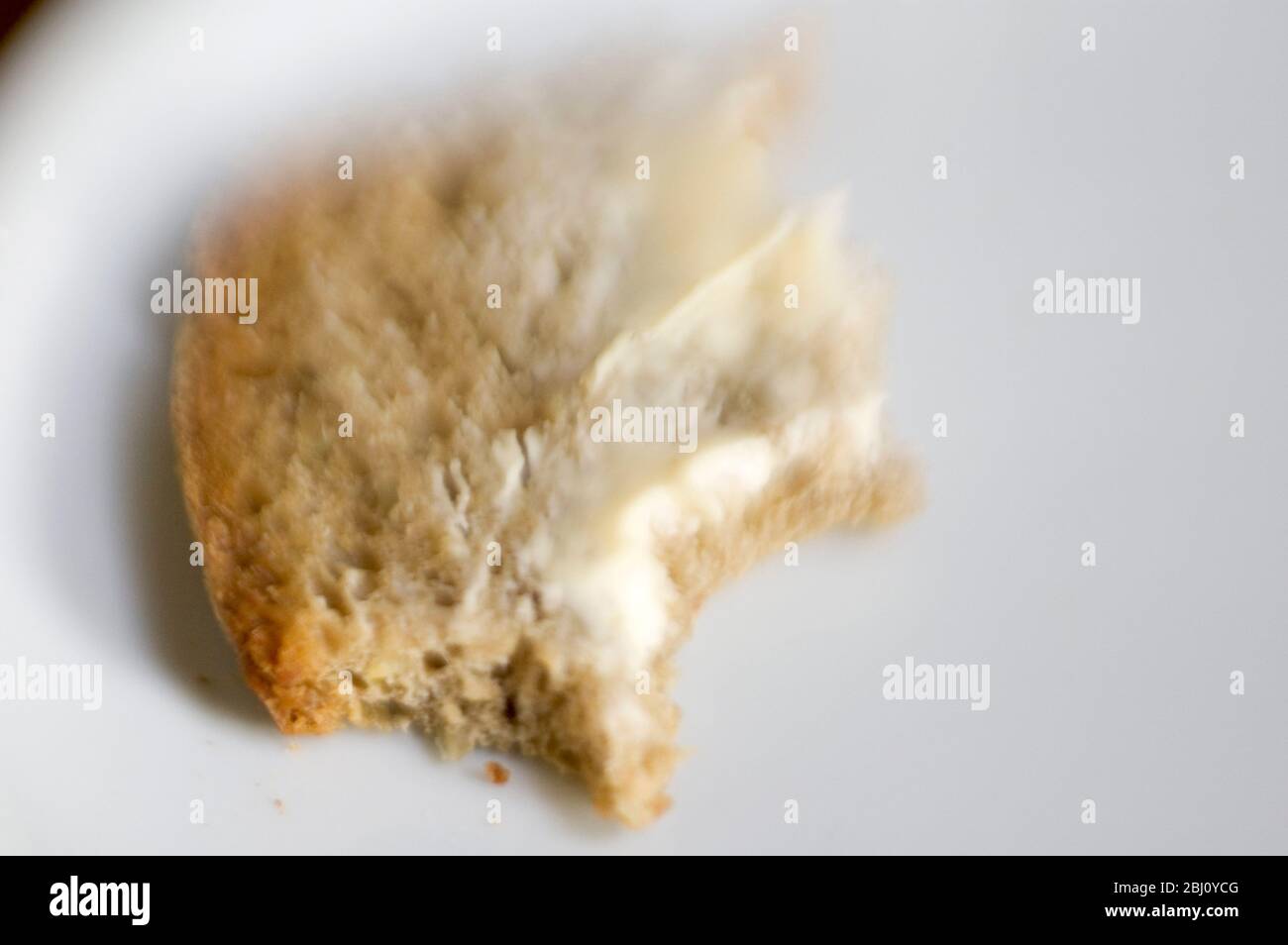 Stück gebuttertes Brot mit Bissen - aufgenommen mit Lenssbaby-Linse für kurze Fokussierung - Stockfoto