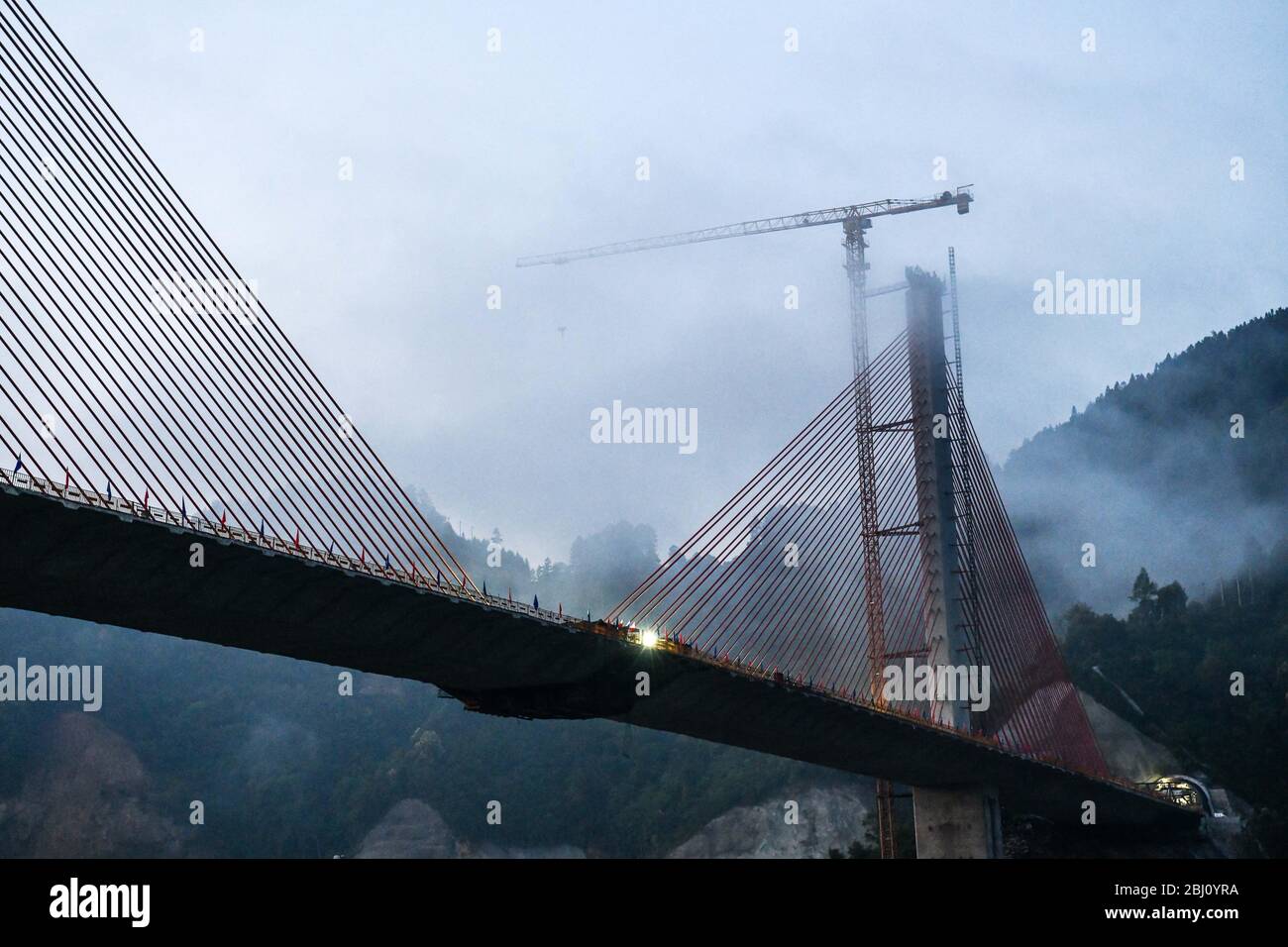 (200428) -- Bezirk JIANHE, 28. April 2020 (Xinhua) -- die beiden Abschnitte der Qingshuijiang Brücke sind im Bezirk Jianhe, südwestlich der Provinz Guizhou, am 28. April 2020, zusammengeschlossen. Als Teil des Jianhe-Rongjiang Expressway ist die Qingshuijiang Seilbahnbrücke 540 Meter lang und 184 Meter hoch. Es wird voraussichtlich Ende Juni für den Verkehr geöffnet. (Xinhua/Yang Wenbin) Stockfoto