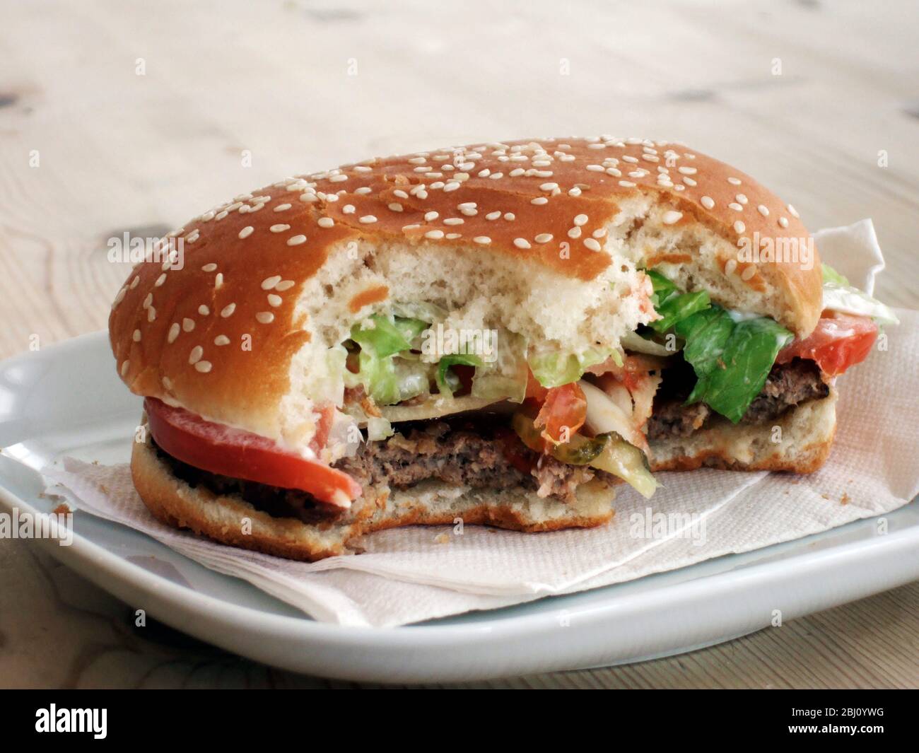 Hamburger gebissen auf weißem Teller - Stockfoto