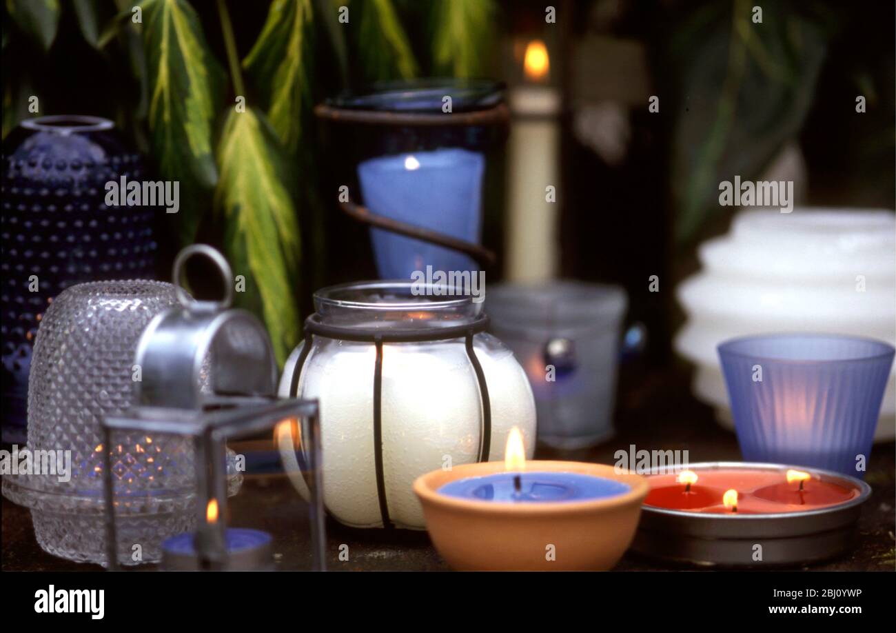 Sammlung von Kerzen und Kerzenhaltern im Abendlicht - Stockfoto