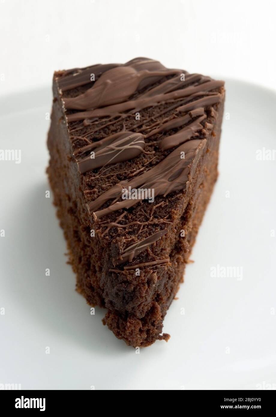 Scheibe von reichhaltiger dunkler Schokoladenkuchen mit geschmolzener Schokoladenüberzug - Stockfoto