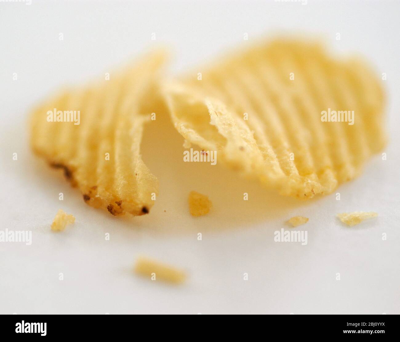 Zerkratztes Kartoffelchips auf weißem Hintergrund - Stockfoto
