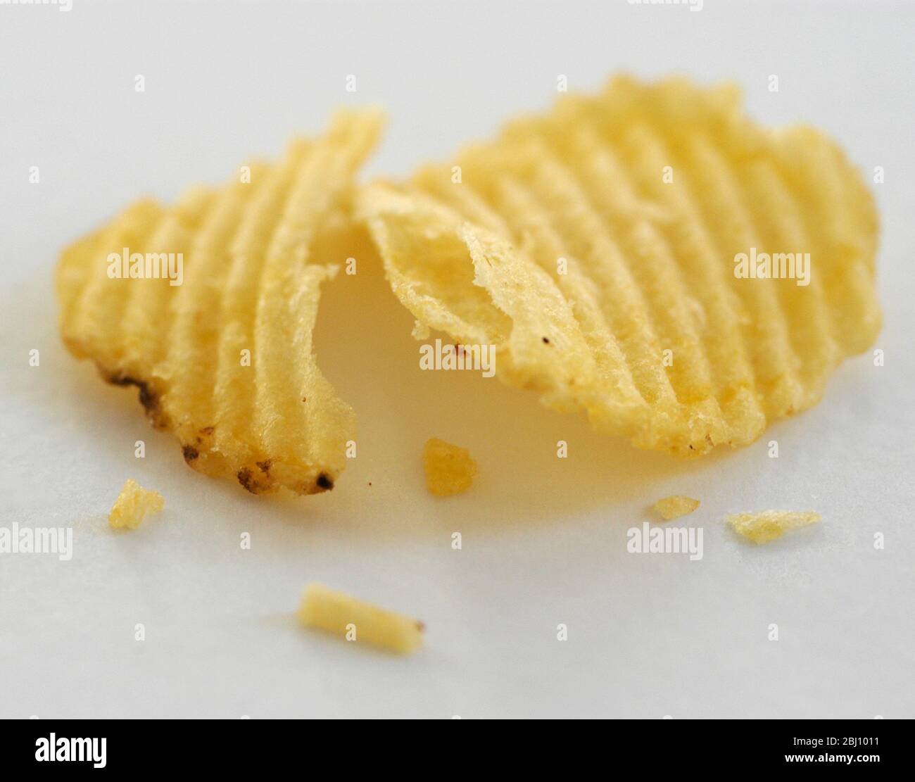 Zerkratztes Kartoffelchips auf weißem Hintergrund - Stockfoto