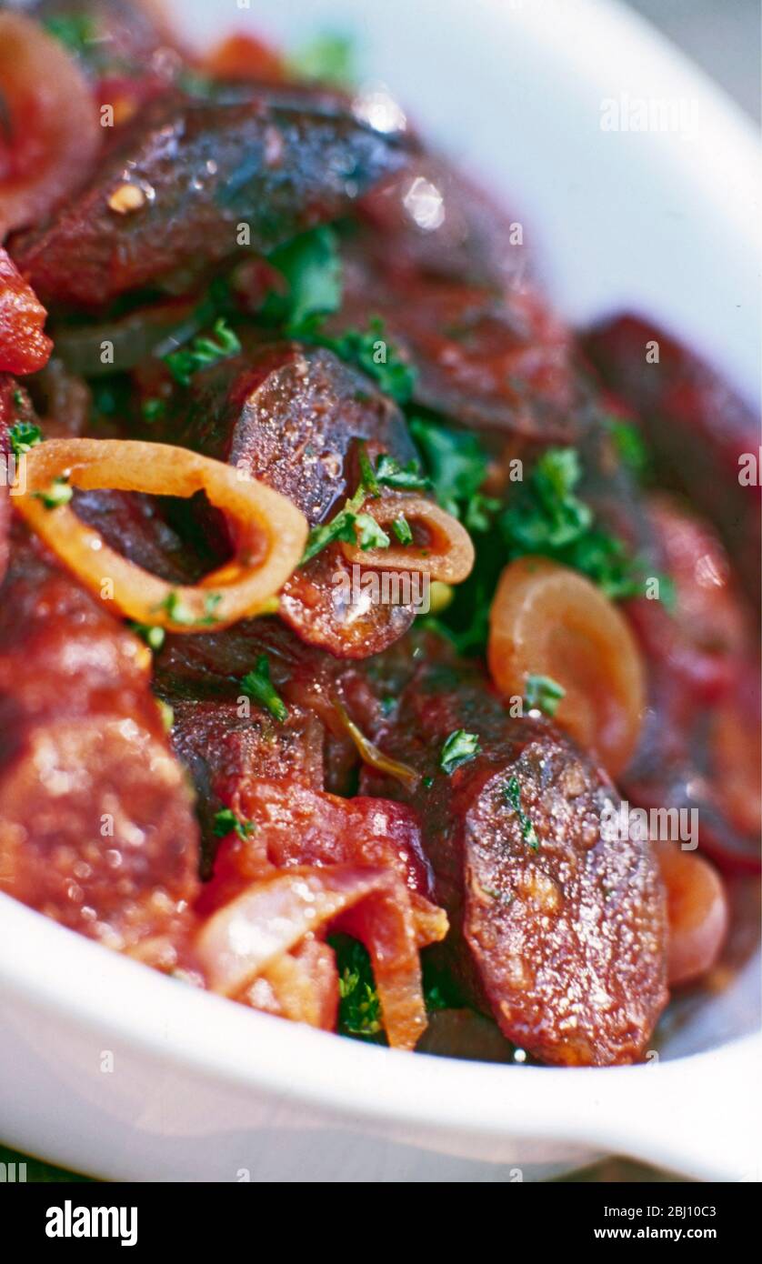 Salat aus würziger französischer Wurst mit Zwiebeln und Petersilie - Stockfoto