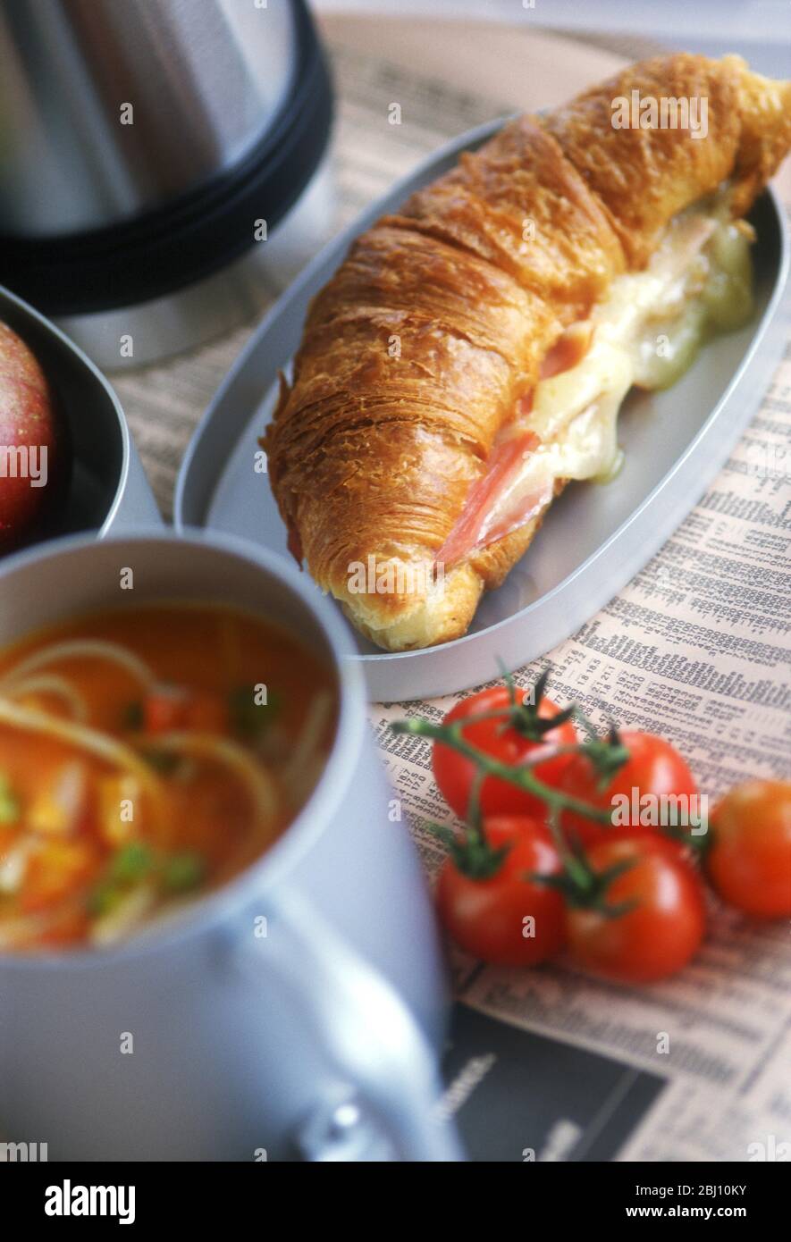 Lunchpaket mit Käse & Schinken gefüllte Croissants mit Tomatensuppe - Stockfoto