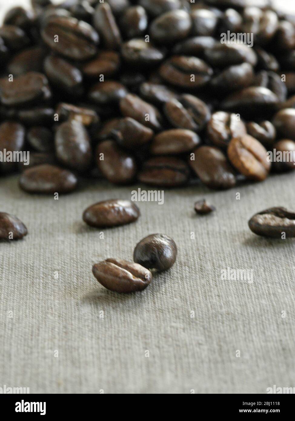 Haufen von dunklen gerösteten Kaffeebohnen auf Leinwand - Stockfoto