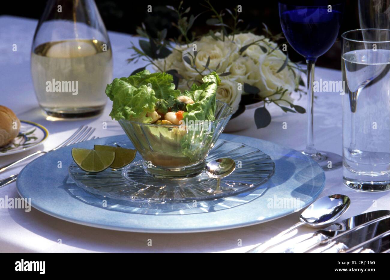 Mittagsfeier im Freien mit Seafood-Salat und Weißwein - Stockfoto