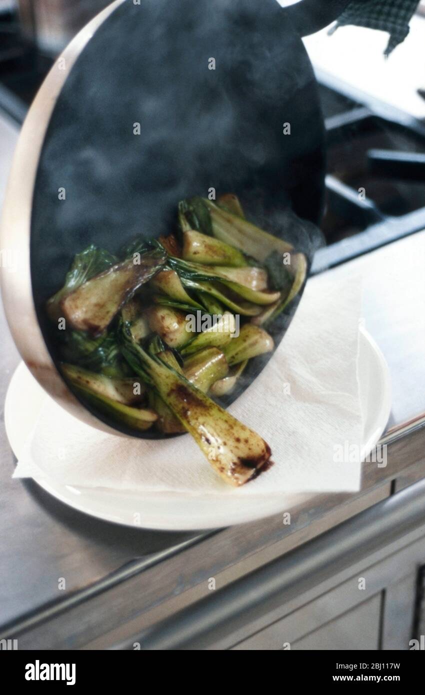 Pakchoi in heißem Sesamöl kochen und mit Sojasauce bestreuen - Stockfoto