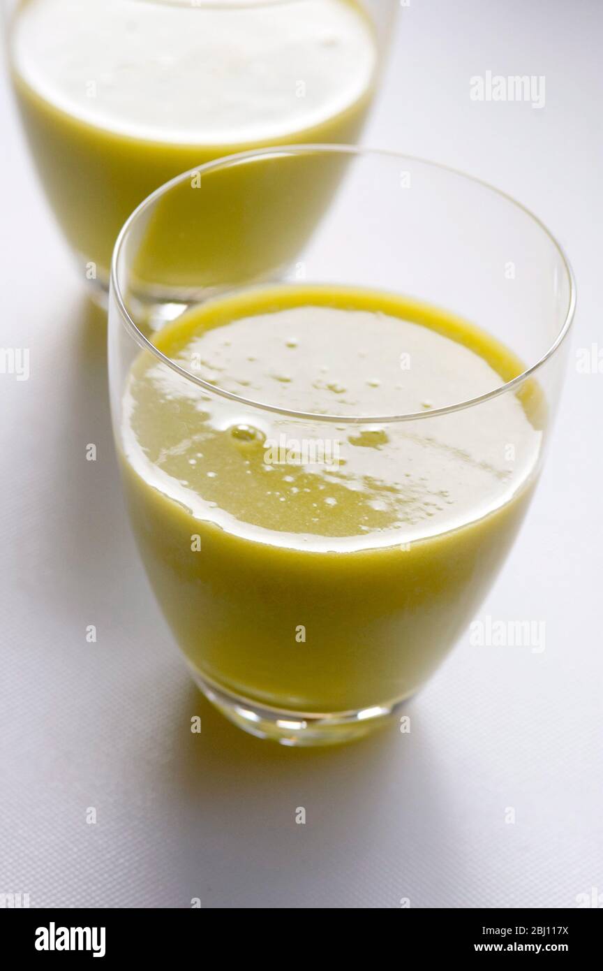 Frisch gesaftet Kiwi Obst und Orange in zwei Gläsern auf weißem Hintergrund - Stockfoto