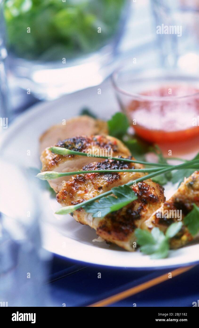 Gegrilltes Hähnchenfilet mit süßer Chilisauce und Salat - Stockfoto