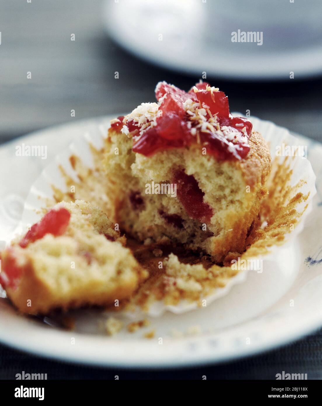 Kirschmuffin auf weißer Platte aufgebrochen - Stockfoto