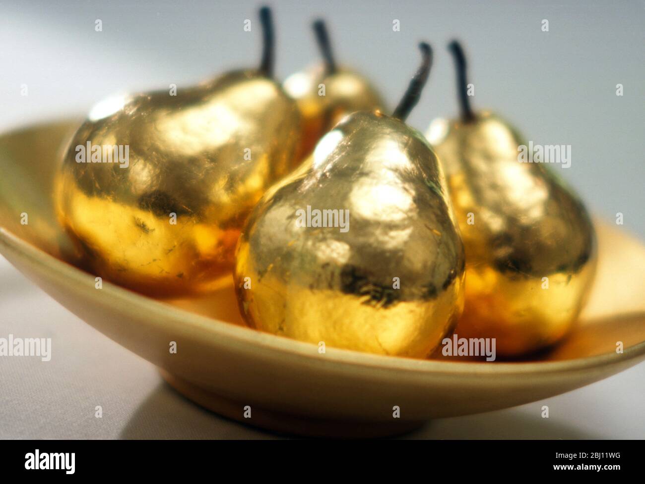 Vier goldene Birnen in goldener Schale - Stockfoto