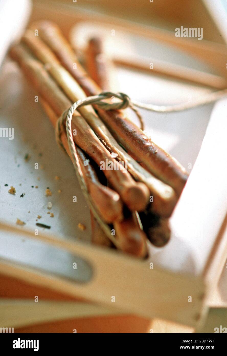 Bündel von hausgemachten Brotstangen auf Holztablett - Stockfoto