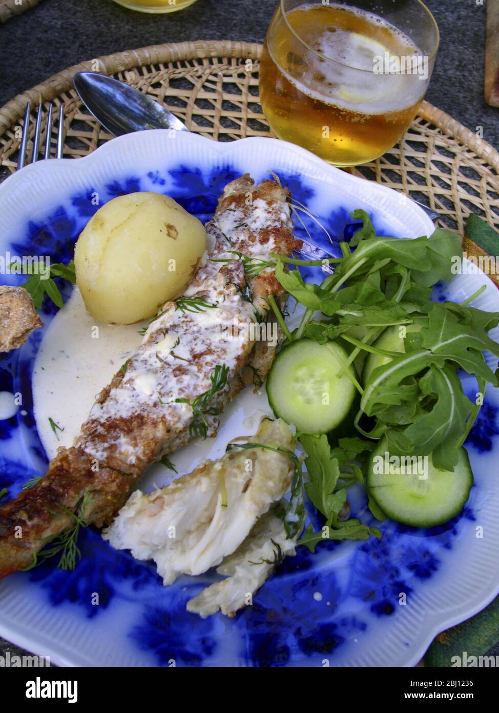 Sommerabendessen Abendessen mit frisch gefangenem Süßwasserfisch, Hecht und Barsch. Serviert im Freien mit einer Gurke und Rucola Salat und einfach gekochte Kartoffeln, a Stockfoto
