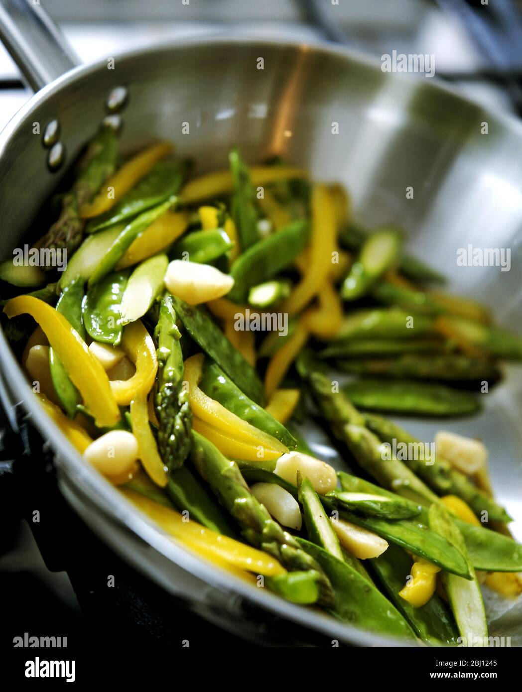 Pfanne mit frischem Gemüse, das unter Rühren gebraten wird - Stockfoto