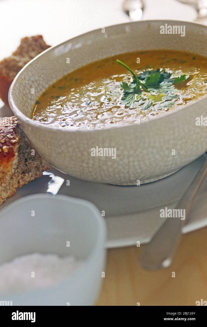 Schüssel mit Karotten- und Koriandersuppe mit knusprigem Brot - Stockfoto