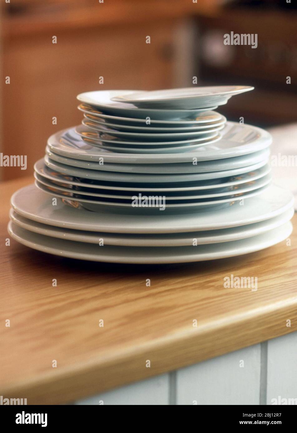Platten in drei verschiedenen Größen auf einer Arbeitsplatte gestapelt - Stockfoto