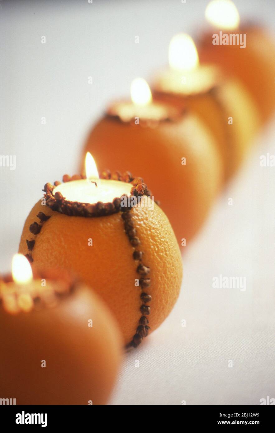 Orange Teelichter mit Nelken eher wie ein Pomander besetzt wäre - Stockfoto