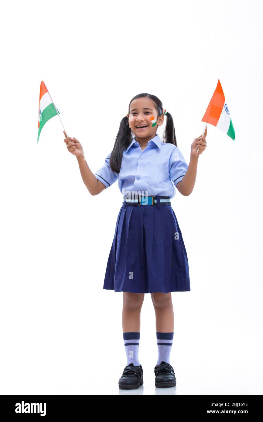 Schulmädchen mit Flagge auf den Wangen gezeichnet und mit Fahnen in der Hand , Unabhängigkeitstag Stockfoto