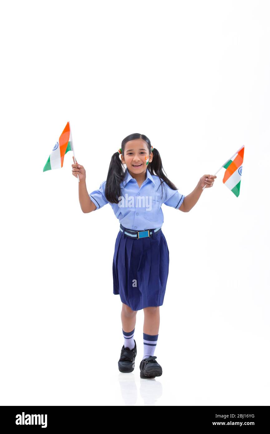 Junge Schulmädchen mit Flagge auf ihren Wangen gezeichnet und hält Fahnen in der Hand , Unabhängigkeitstag Stockfoto