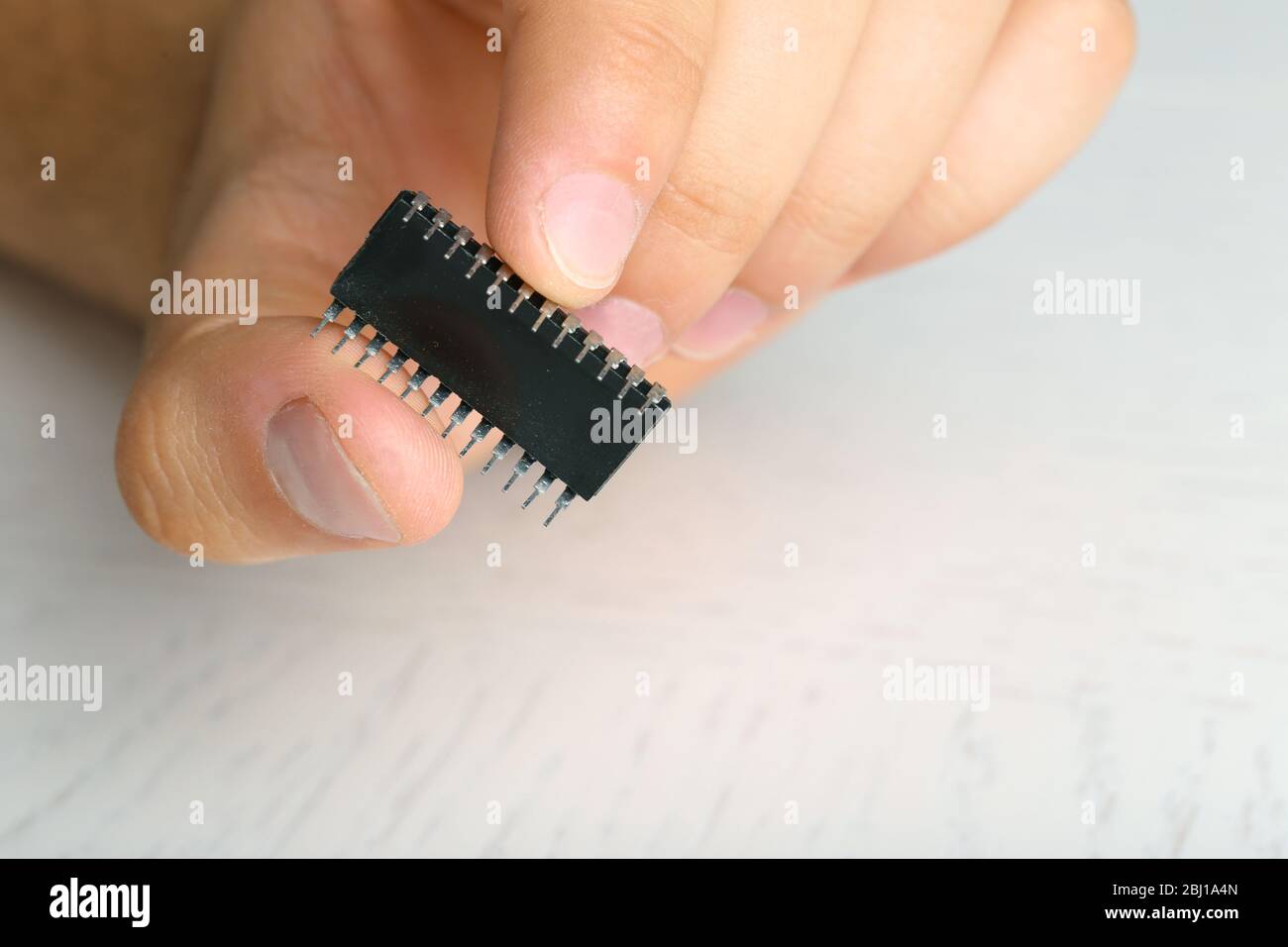 Männliche Finger halten Mikrochip isoliert auf weiß Stockfoto