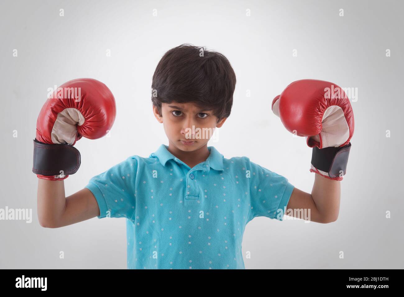 Porträt eines jungen Jungen mit Boxhandschuhen Stockfoto