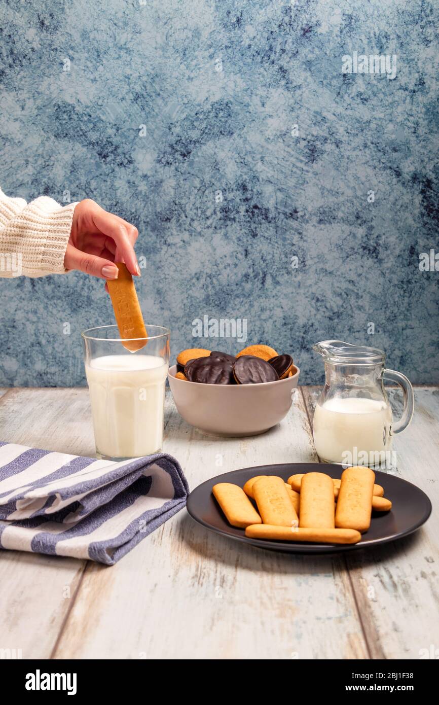 Leckere Kekse mit Milchglas auf einer Tischplatte Stockfoto