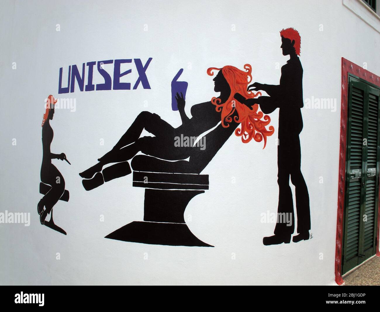 Unisex-Friseursalon, Unisex-Friseursschild, an der Wand gemalt, eine Frau im Stuhl mit einem Haarschnitt Stockfoto