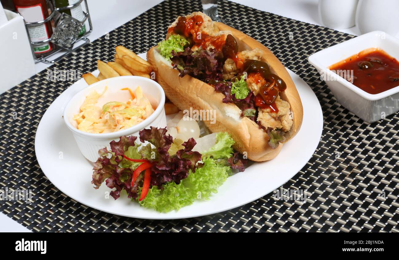 Zinger Chicken Sandwich mit Krautsalat und Kartoffelpuddinger Stockfoto