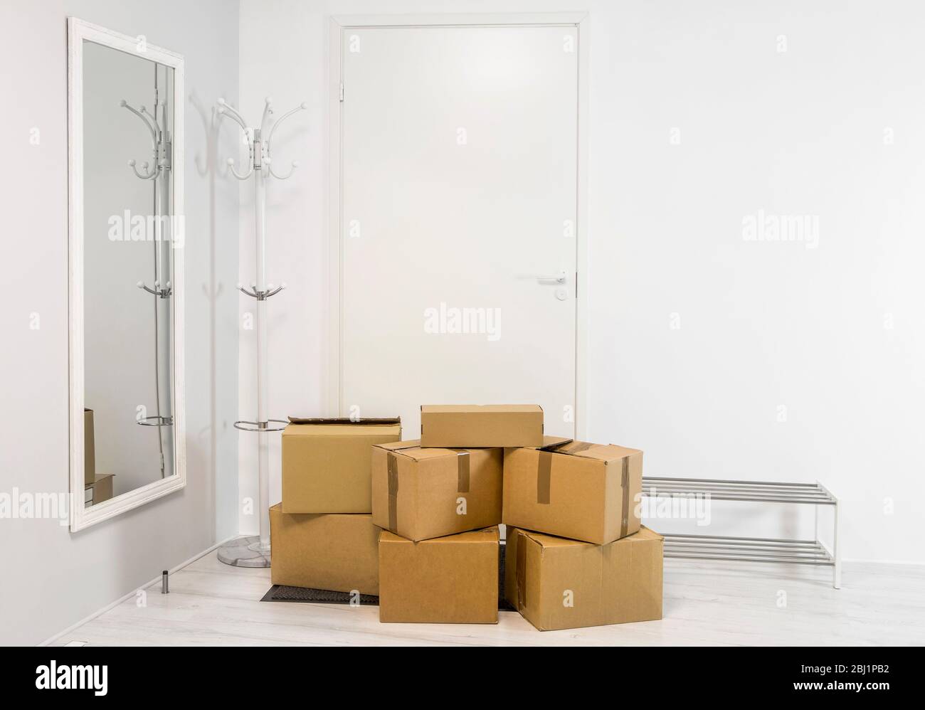 Stapel von Pappkartons in weiß minimalistisch weißen Hausflur. Viel Platz für Text. Stockfoto