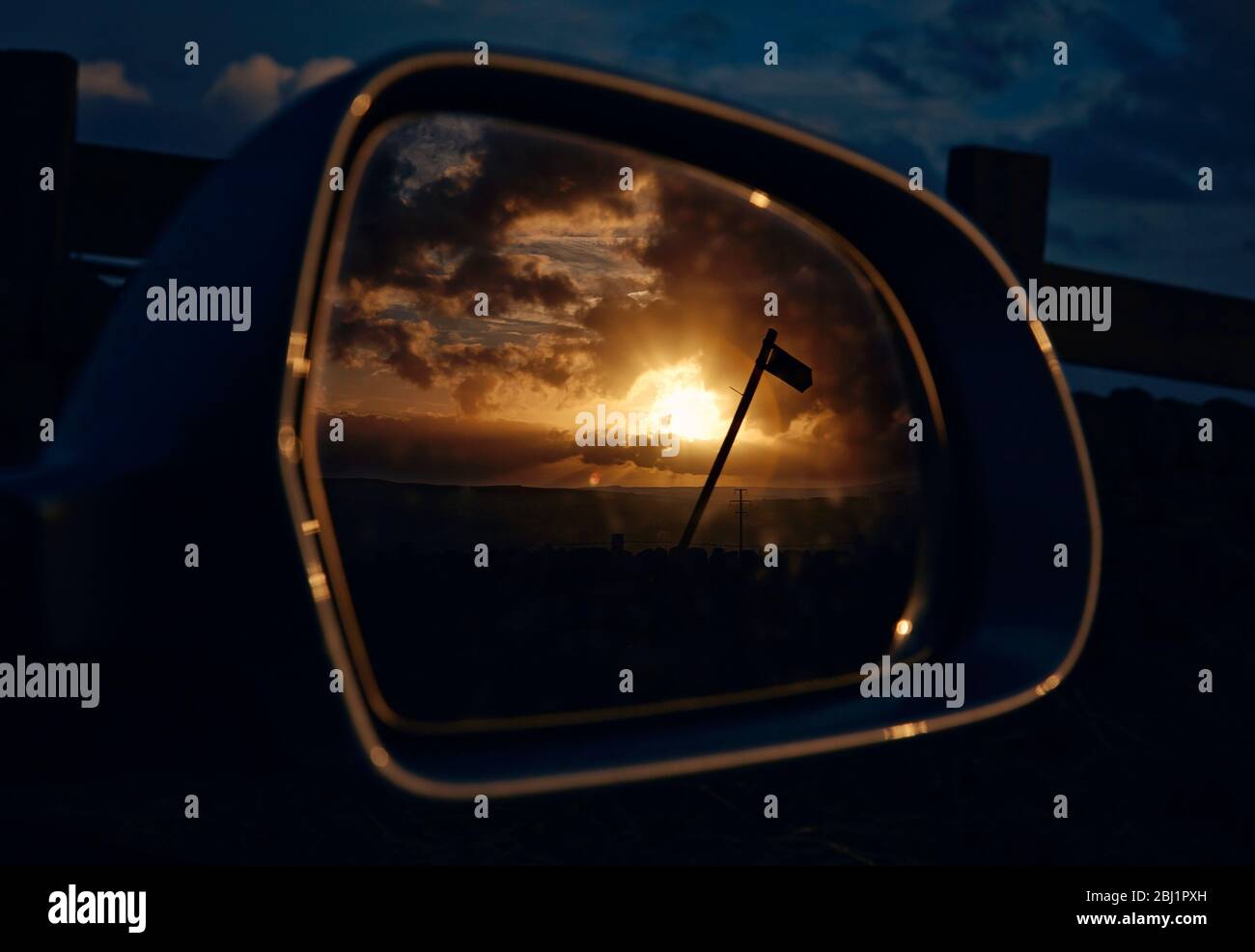 Car Wing Spiegel reflektieren Sonnenuntergang und öffentliche Fußweg Schild Stockfoto