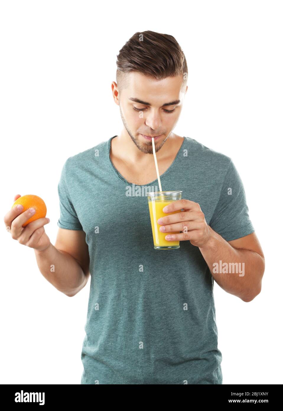 Junger Mann, der Orangensaft trinkt, isoliert auf Weiß Stockfoto