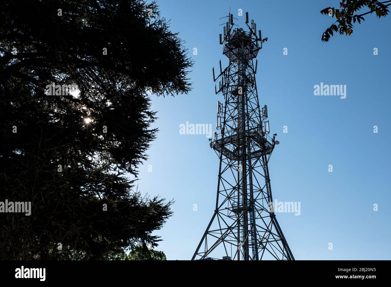 Silhouette der Antenne für Mobiltelefone Telekommunikation und Bäume in Hintergrundbeleuchtung verwendet. Mobilfunkturm. Stockfoto