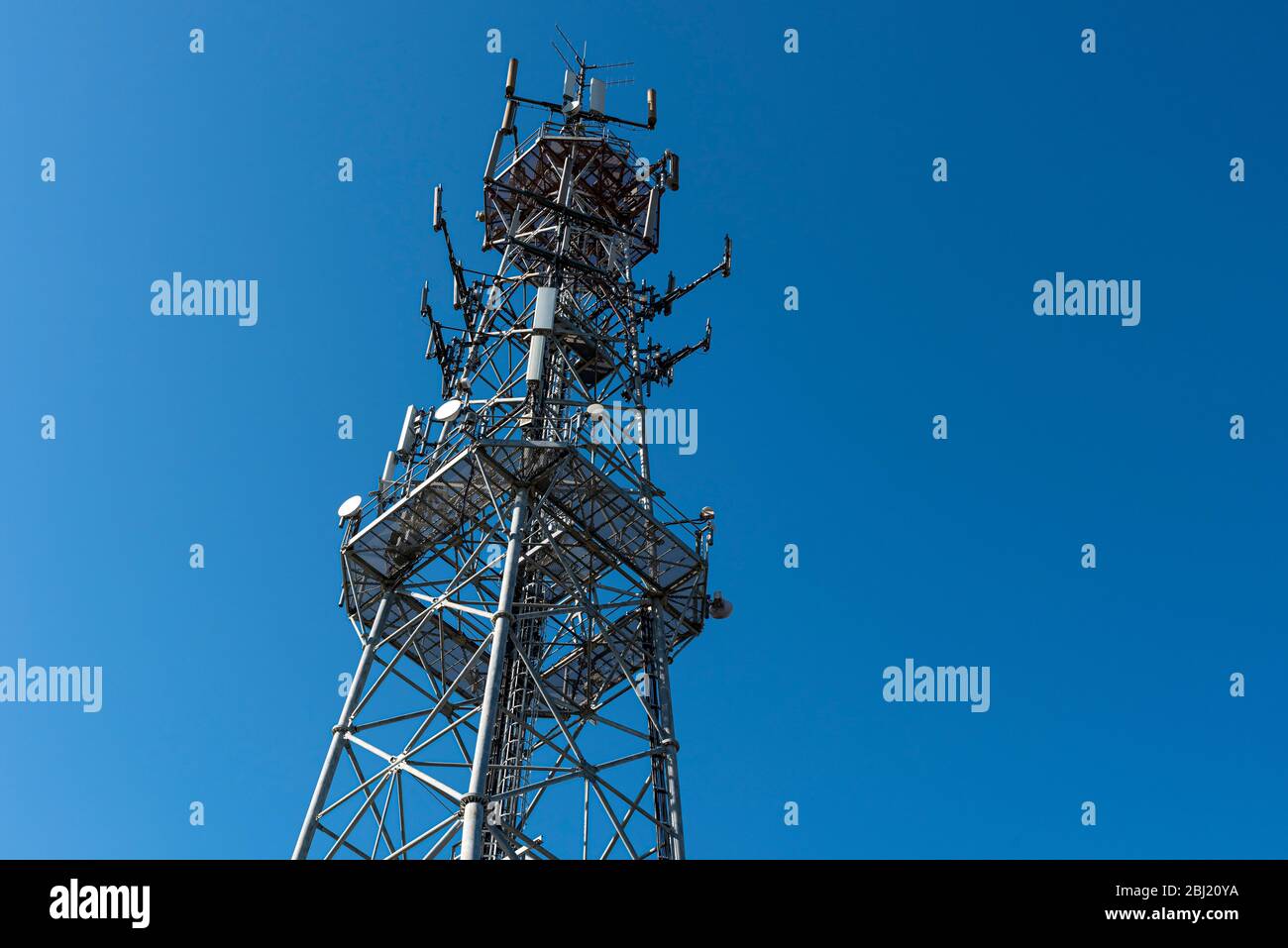 Mobilfunkturm an einem sonnigen Tag. Antenne für Mobiltelefone Telekommunikation verwendet. Stockfoto
