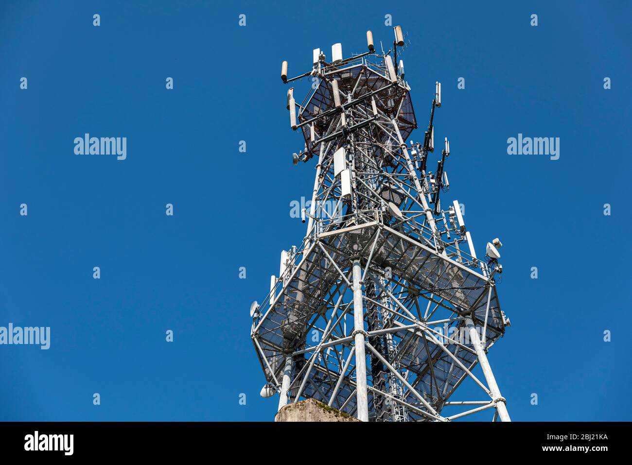 Mobilfunkturm gegen blauen Himmel. Detail der Antenne für die Telekommunikation von Mobiltelefonen. Stockfoto