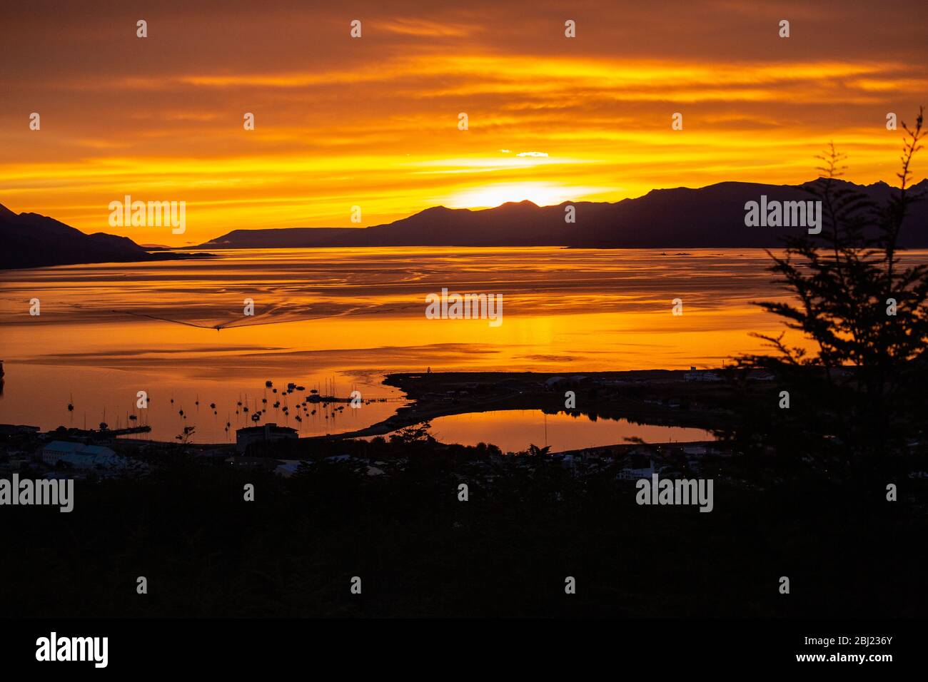 Sonnenuntergang über der Bucht mit Bergen am Horizont. Stockfoto