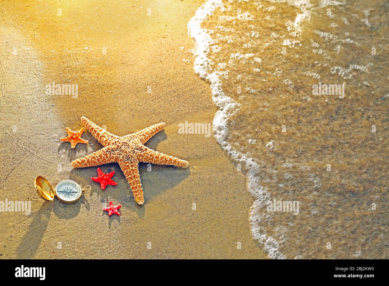 Kompass mit Seesternen auf Sand Strand Hintergrund Stockfoto