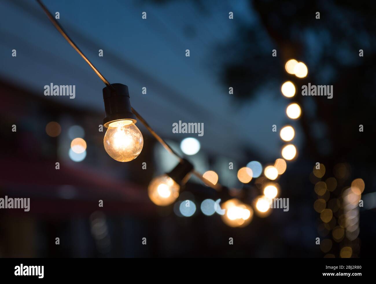 Eine Reihe von Glühlampen in der Straße und Bokeh. Stockfoto