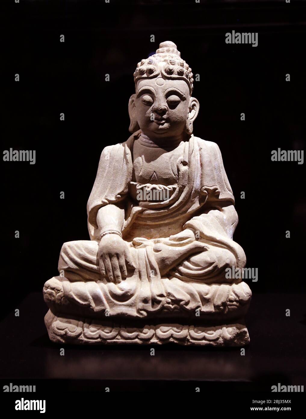 Buddha-Statue, in Stein gemeißelt. Yuan-Dynastie (1271-1368). Chinesse Kunst 13.-14. Jahrhundert. Das Museu do Oriente, Lissabon, Portugal. Stockfoto