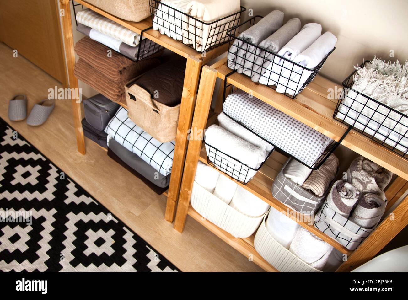 Eine Frau macht die Frühjahrsputz. Zusammenklappbar für Bettwäsche, Decken, Handtücher und Bettbezüge in einem Schrank. Das Konzept der Hausarbeit und Lagerung. Stockfoto