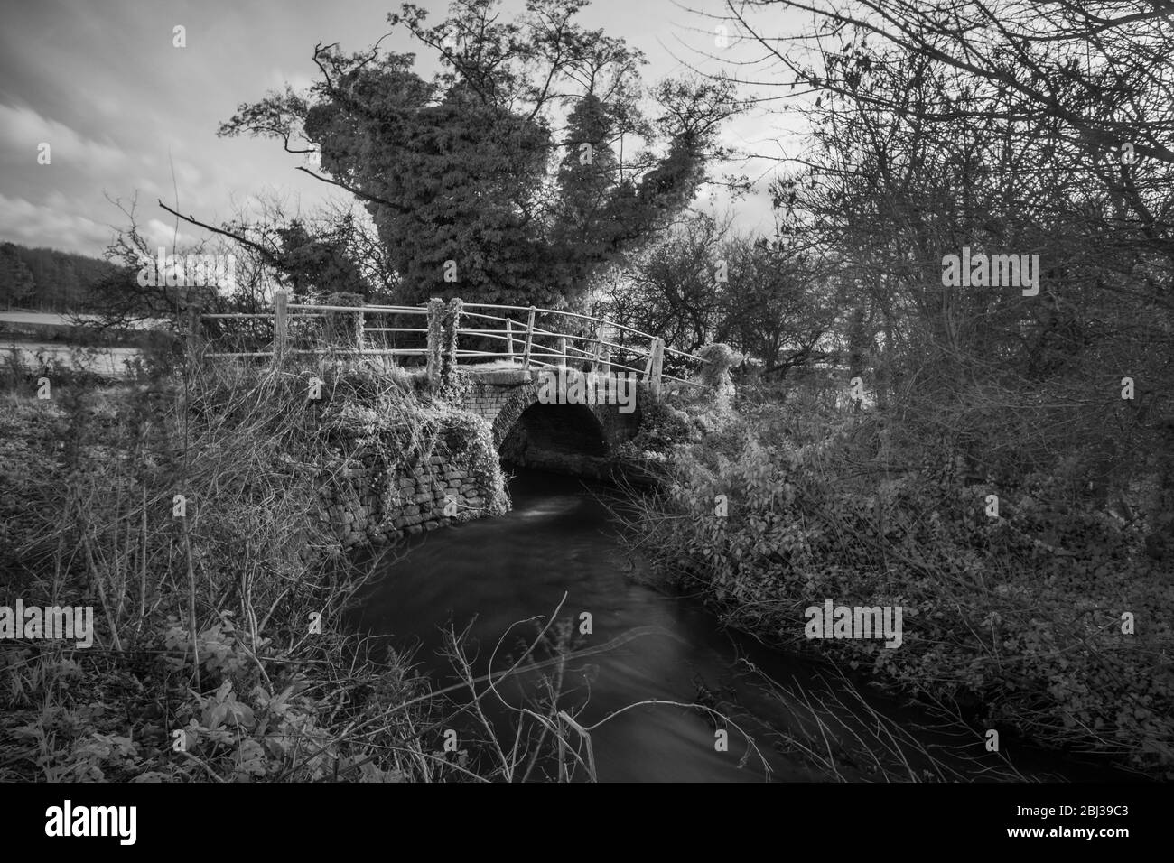 Backsteinbrücke über den Fluss Stiffkey, Norfolk, England. Schwarz-Weiß-Infrarotbild. Stockfoto