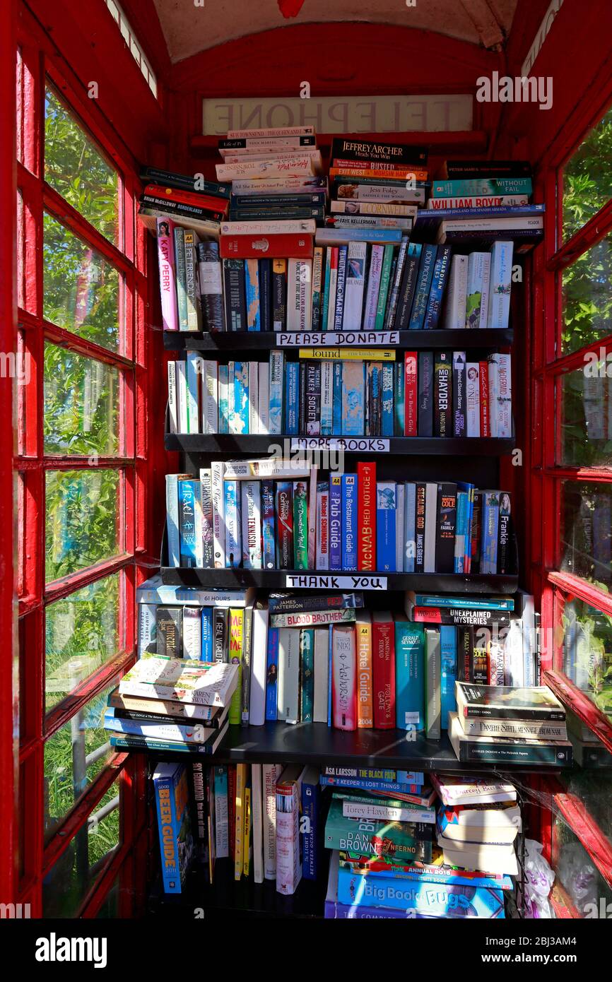 In einer alten roten Telefonbox, die jetzt als kostenlose Bibliothek im ländlichen West Yorkshire, England, verwendet wird. Stockfoto