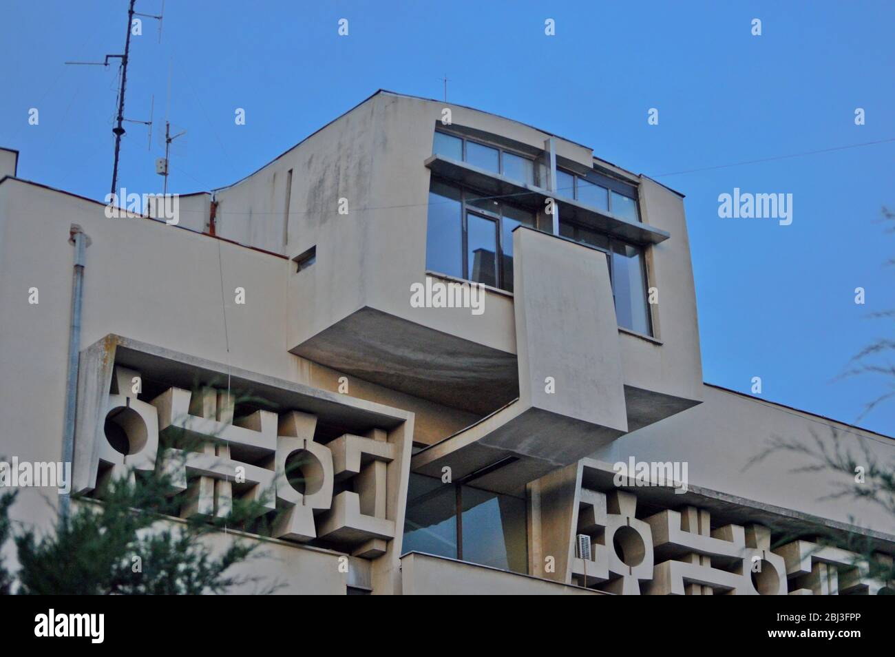 Die Fassade eines alten kommunistischen Gebäudes, gerade Linien und grauer Beton beschreiben am besten den architektonischen Stil Osteuropas während des Kommunismus Stockfoto