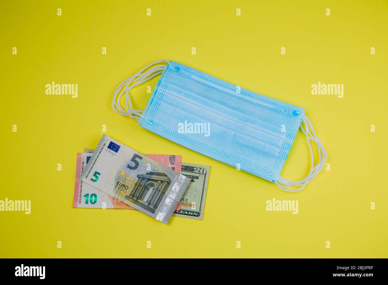 Medizinische Gesichtsmaske und Geld auf einem gelben Hintergrund, Welt Coronavirus Epidemie und wirtschaftlichen Schäden. Corona Virus Konzept. Stockfoto Medizinische Gesichtsmaske und Geld auf einem gelben Hintergrund, Welt Coronavirus Epidemie und wirtschaftlichen Schäden. Corona Virus Konzept. Stockfoto
