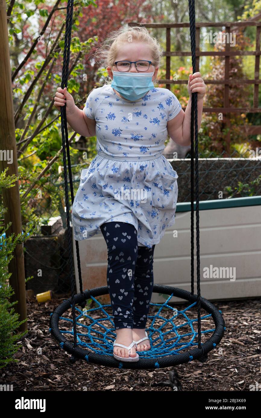 Kind trägt Facemask während Covid-19, Coronavirus-Pandemie. UK (Wales) Es ist ein ehrliche nicht ein posierte Bild während der "Lockdown" aufgenommen. Stockfoto