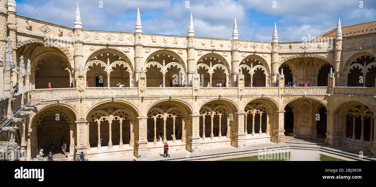 Touristen passieren Steinsäulen und Kreuzgänge des berühmten Klosters von Jeronimos - Mosteiro dos Jeronimos in Lissabon, Portugal Stockfoto