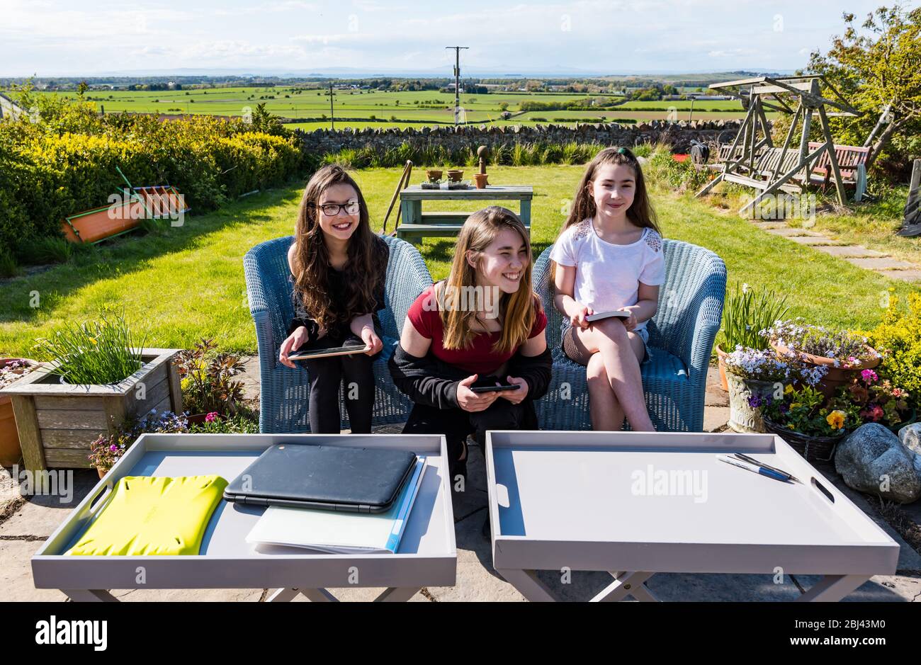 Camptoun, East Lothian, Schottland, Vereinigtes Königreich. April 2020. Eine Gemeinde im Lockdown: Bewohner einer kleinen ländlichen Gemeinde zeigen, wie das Leben im Lockdown für sie ist. Im Bild (L bis R): Imogen, Eva und Louisa. Imogen und Louisa sind Zwillinge im Alter von 11 Jahren in P7. Sie können den normalen Übergang zur High School verpassen. Eva ist S2 und 13 Jahre alt. Sie sind zu Hause Schulbildung Stockfoto