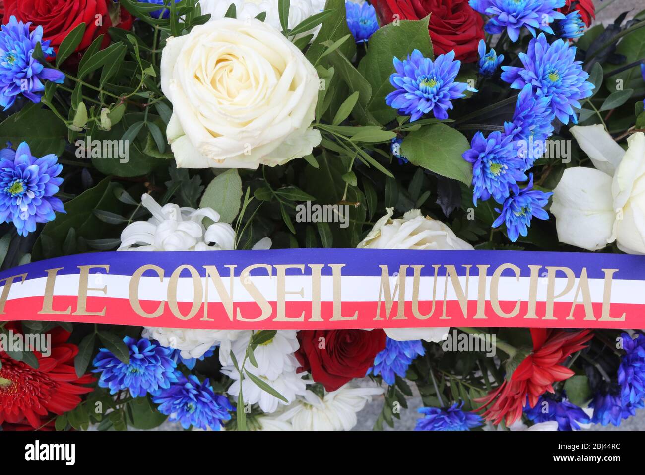 Gerbe de fleurs déposée au pied'un Monument aux morts lors de la cérémonie du 11 novembre. Stockfoto